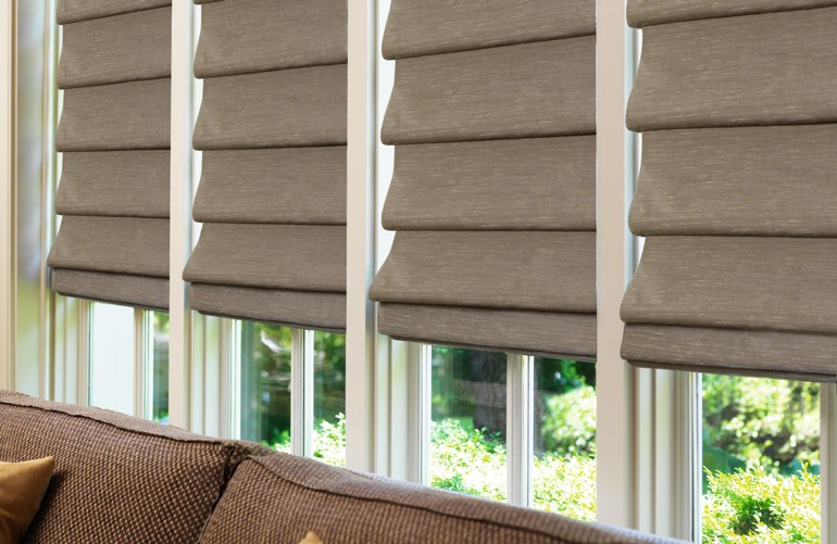 Sunroom window with brown Roman shades